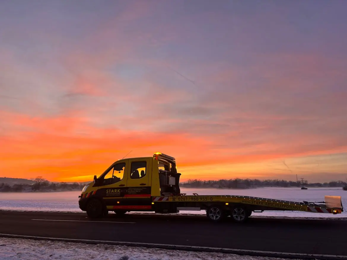 STARK Abschleppdienst Koblenz im winterlichen Sonnenuntergang, bereit für Fahrzeugtransport und Pannenhilfe.