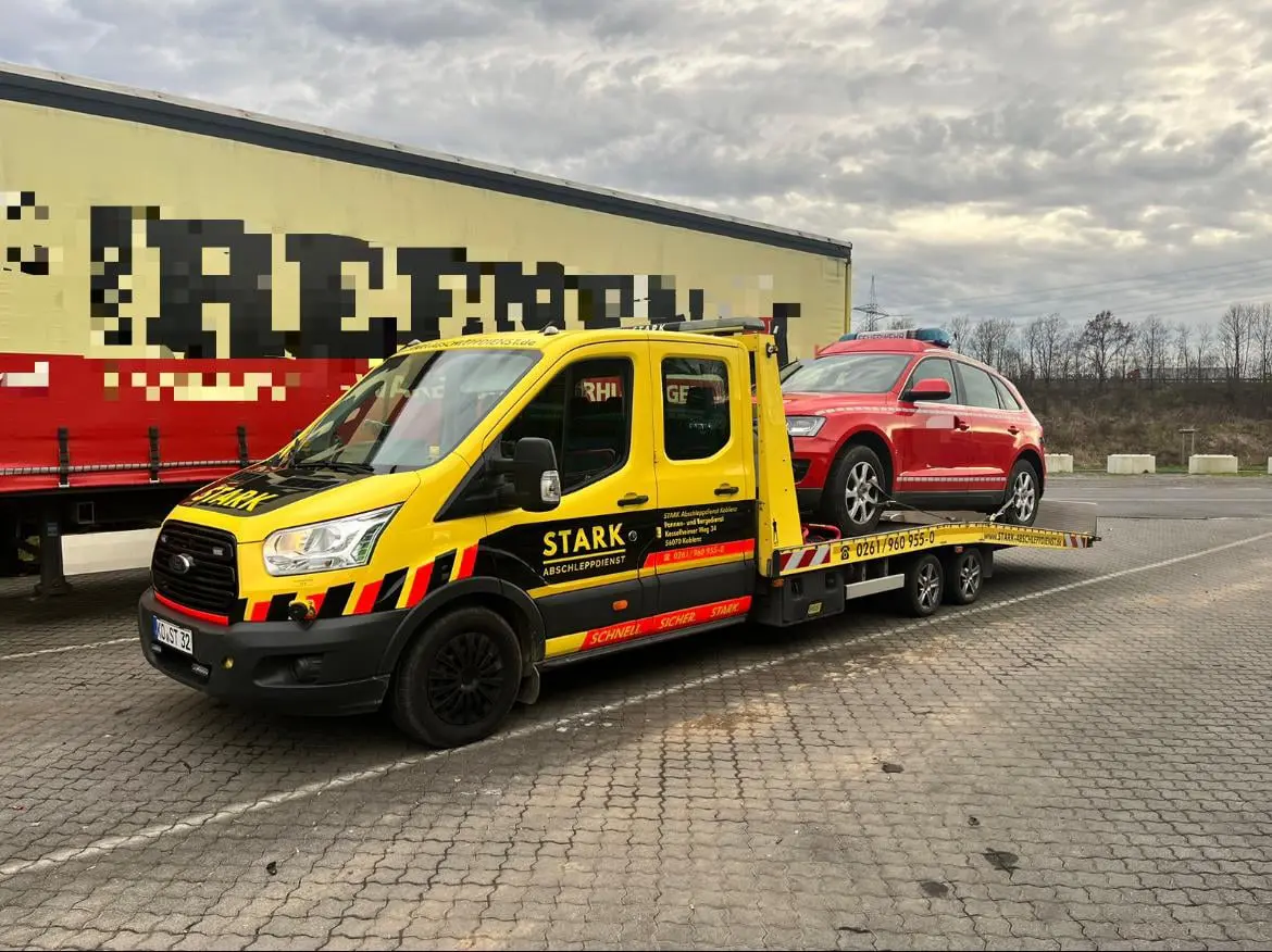 STARK Abschleppdienst Koblenz führt sorgfältigen Transport eines roten SUVs von der Feuerwehr durch und demonstriert Fachkompetenz in jedem Pannenfall.