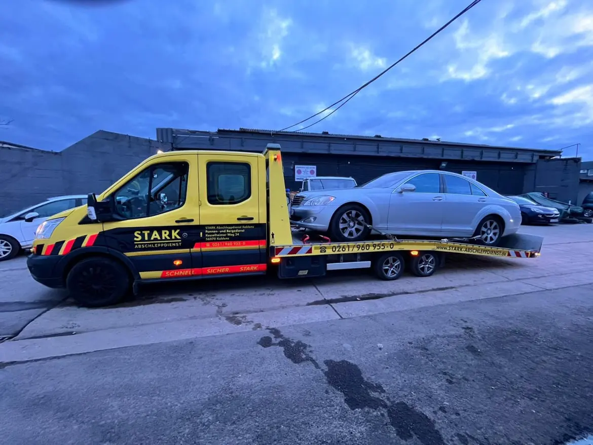 STARK Abschleppdienst Koblenz beim sicheren Transport eines weißen PKWs, zeigt Zuverlässigkeit und Professionalität im Abschleppservice.